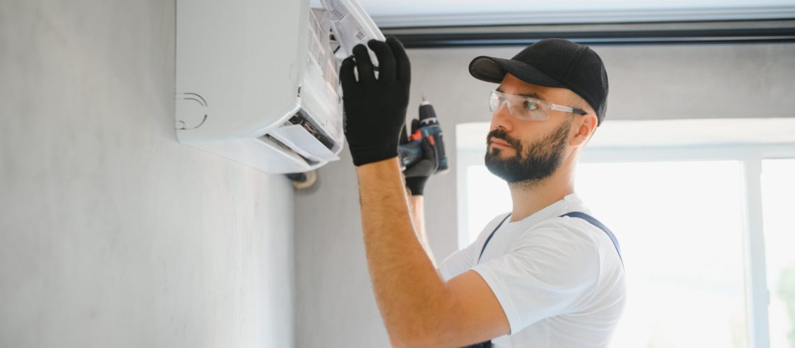 Happy Male Technician Repairing Air Conditioner.